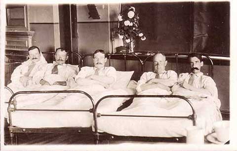 Men in bed postcard